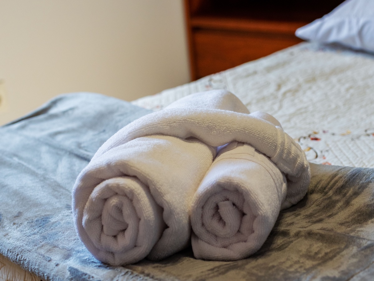 Serviettes de bain roulées sur un lit préparé dans une maison Marévilla à Jard-sur-Mer